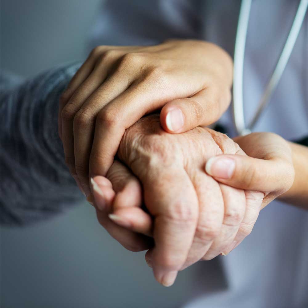 Hands of practitioner and elder patient